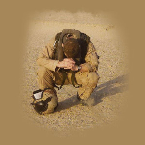 soldier praying in sand